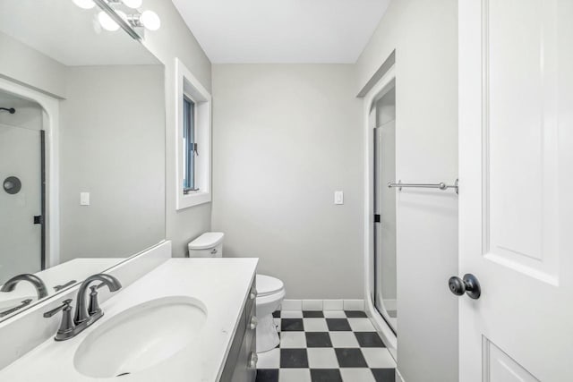 bathroom featuring toilet, an enclosed shower, and vanity