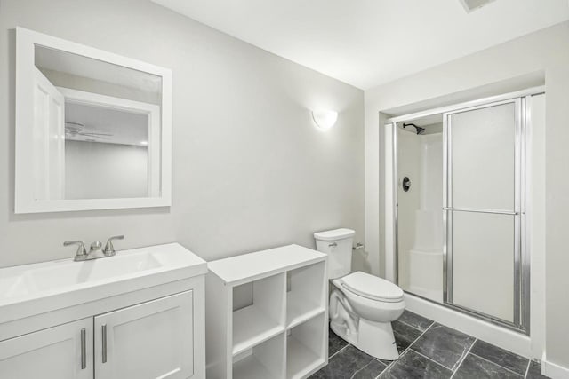 bathroom with vanity, toilet, ceiling fan, and a shower with shower door