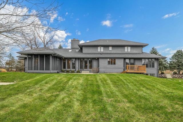 rear view of house with a lawn and a sunroom