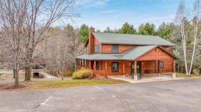 cabin with covered porch and a patio area