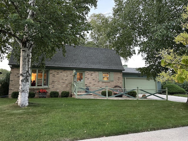 view of front facade with a front yard, concrete driveway, brick siding, and roof with shingles