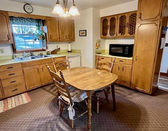 kitchen featuring black microwave, light countertops, decorative light fixtures, and brown cabinets