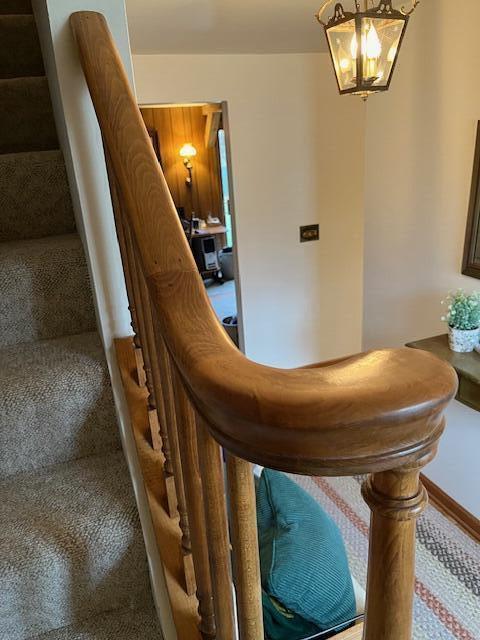 stairway featuring a notable chandelier and baseboards