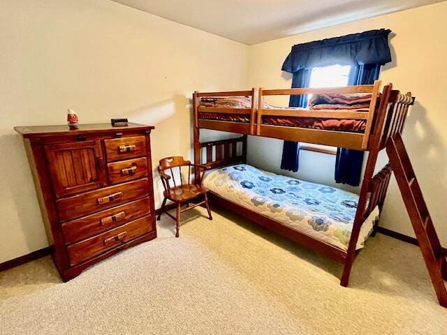 bedroom with light carpet and baseboards