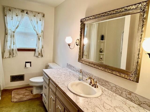 full bathroom featuring toilet, baseboards, visible vents, and vanity