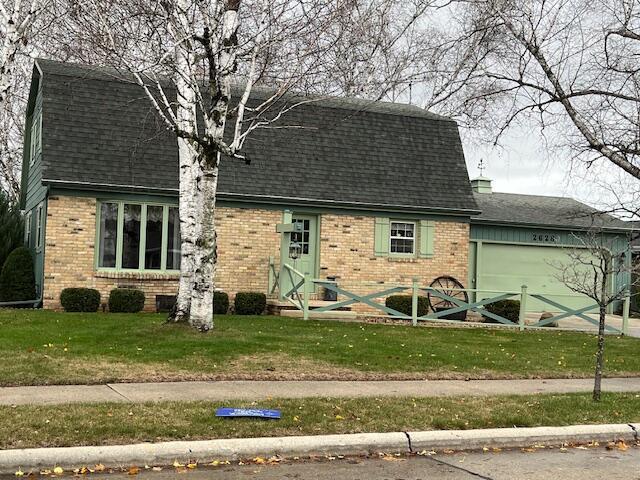 2628 Riverhills Rd, Two Rivers, WI 54241 - colonial inspired home featuring brick siding, a shingled roof, and a garage