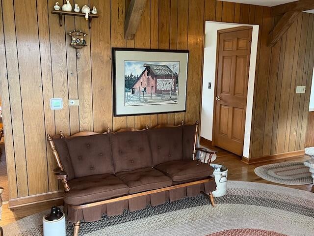 living area with wooden walls, baseboards, and wood finished floors