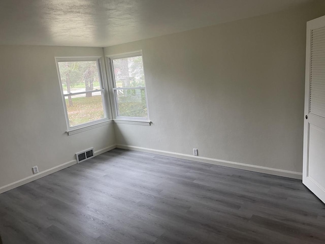 spare room with dark hardwood / wood-style flooring