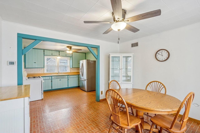 dining space with ceiling fan and sink