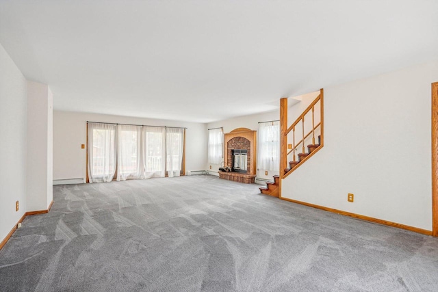 unfurnished living room featuring baseboard heating, carpet floors, and a brick fireplace