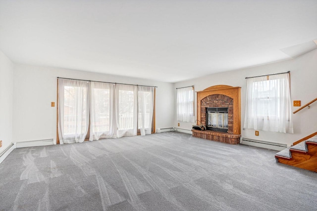 unfurnished living room featuring carpet, a brick fireplace, plenty of natural light, and a baseboard heating unit