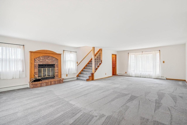 unfurnished living room with light carpet, a brick fireplace, and baseboard heating