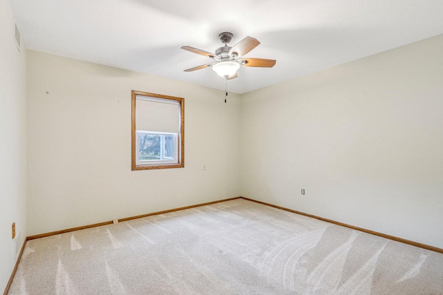 empty room with ceiling fan and light colored carpet