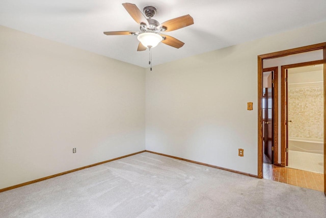 spare room with ceiling fan and light colored carpet