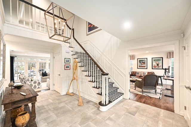 stairs with crown molding, a chandelier, and hardwood / wood-style flooring