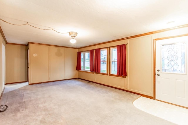 carpeted entrance foyer featuring crown molding