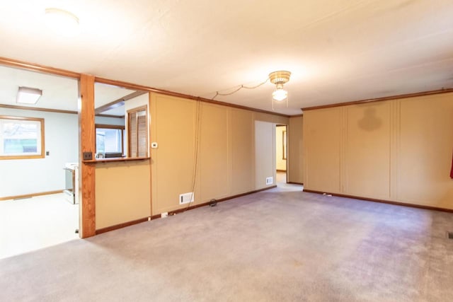 unfurnished room featuring light colored carpet and crown molding