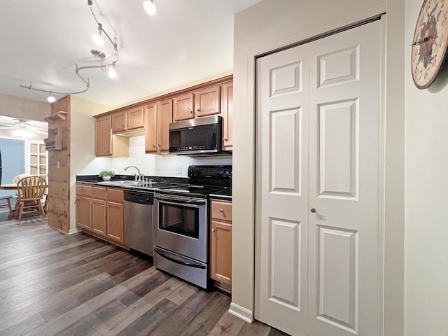 kitchen with dark hardwood / wood-style flooring, sink, track lighting, and appliances with stainless steel finishes