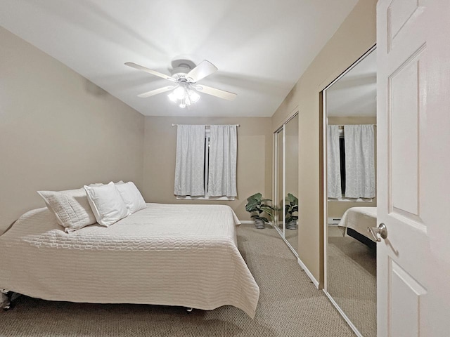 carpeted bedroom with baseboard heating and ceiling fan