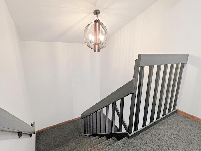 staircase with a notable chandelier and carpet flooring