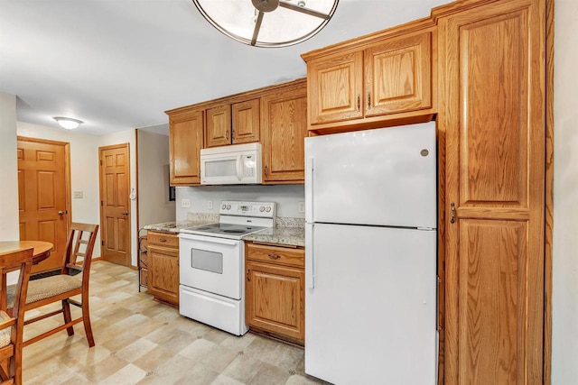 kitchen featuring white appliances and light stone counters