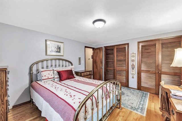 bedroom featuring light wood-type flooring and multiple closets