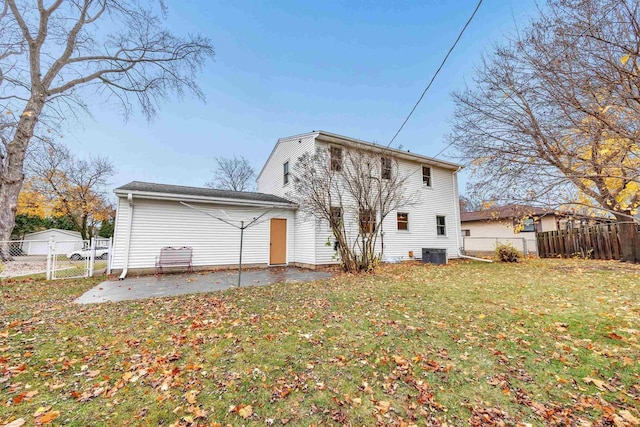 back of property featuring a lawn, central air condition unit, and a patio area