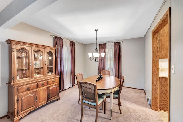 dining room featuring light colored carpet and a chandelier