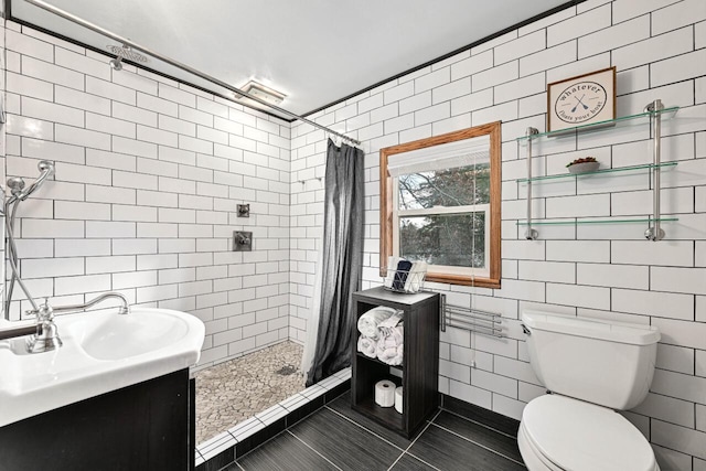 bathroom with vanity, tile patterned flooring, toilet, tile walls, and walk in shower