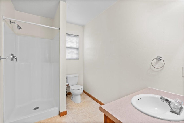 bathroom featuring vanity, toilet, and a shower