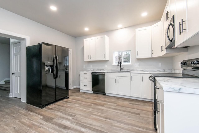 kitchen with light stone counters, sink, black appliances, light hardwood / wood-style flooring, and white cabinetry