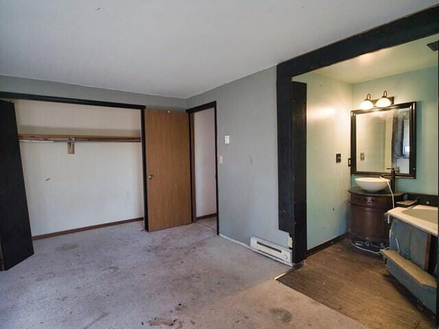 bedroom featuring light colored carpet, sink, and a closet