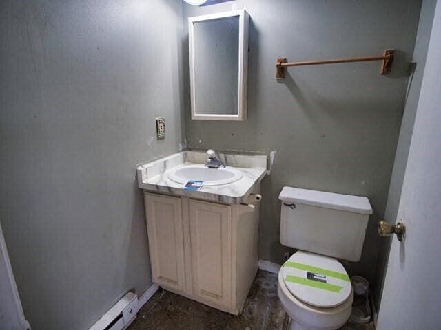 bathroom featuring vanity, a baseboard heating unit, and toilet