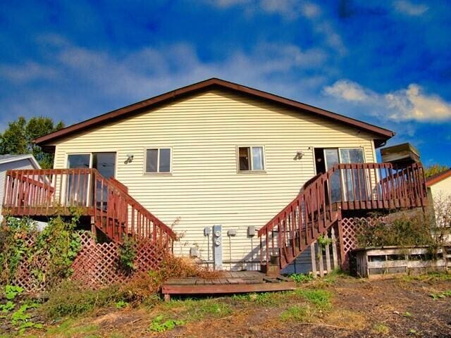 rear view of house featuring a wooden deck