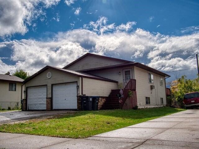 view of front of home featuring a front lawn and a garage