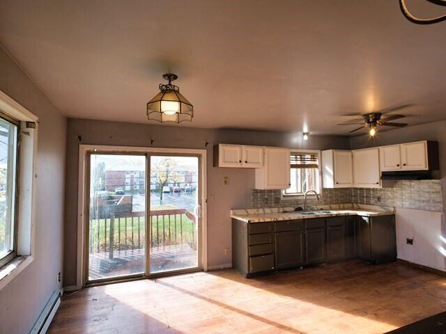 kitchen featuring white cabinetry, a healthy amount of sunlight, and a baseboard radiator