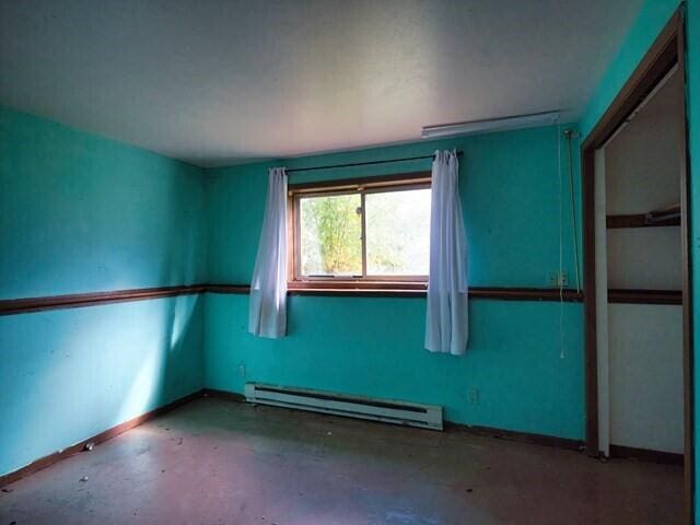 empty room featuring concrete floors and a baseboard radiator