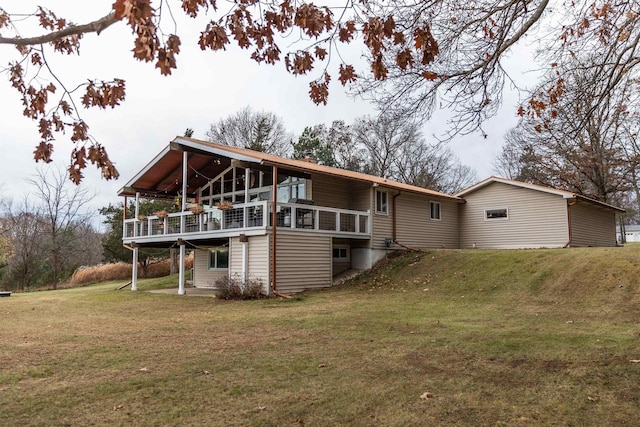 rear view of property featuring a yard and a deck