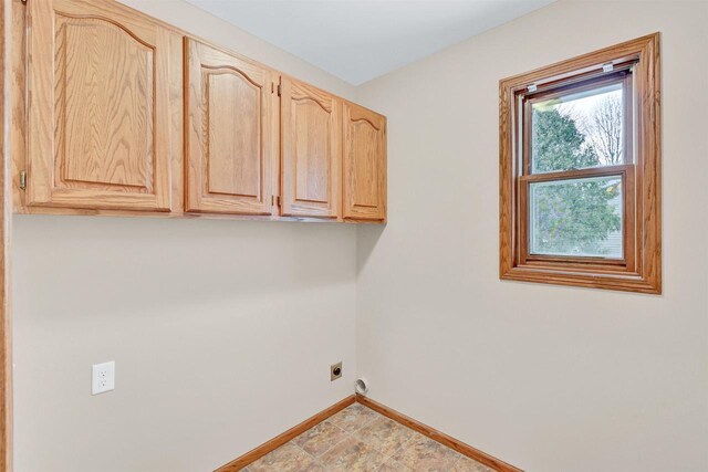 laundry area featuring electric dryer hookup and cabinets