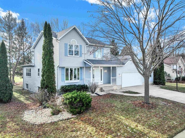 front of property featuring covered porch and a garage