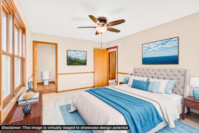 carpeted bedroom featuring multiple windows, ensuite bathroom, and ceiling fan