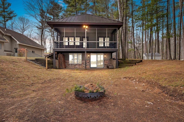 back house at dusk featuring a sunroom