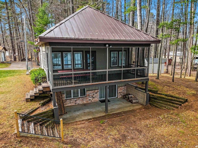 back of property featuring a patio and a sunroom