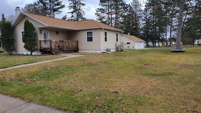 exterior space featuring a lawn, an outbuilding, and a garage