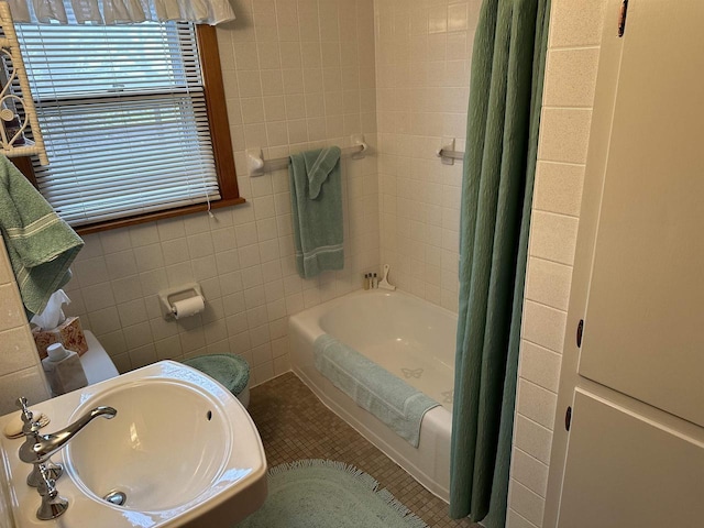 bathroom featuring tile patterned flooring, shower / bath combo, tile walls, and sink