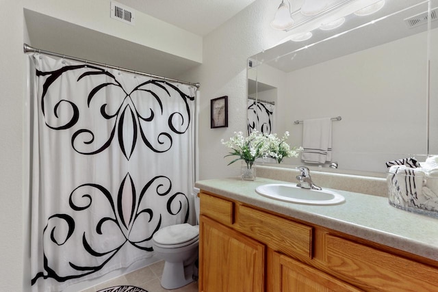 bathroom with tile patterned flooring, vanity, and toilet