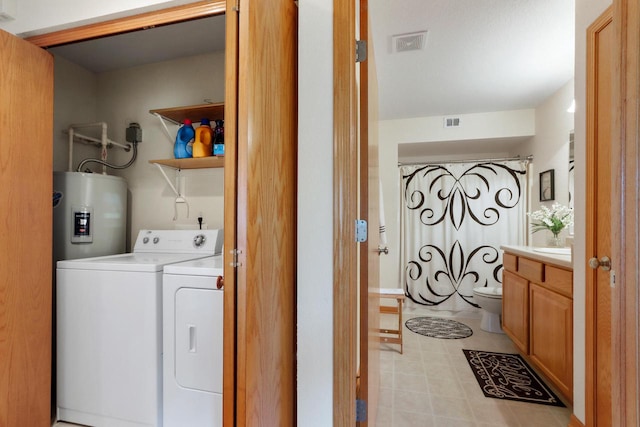 washroom featuring water heater and independent washer and dryer