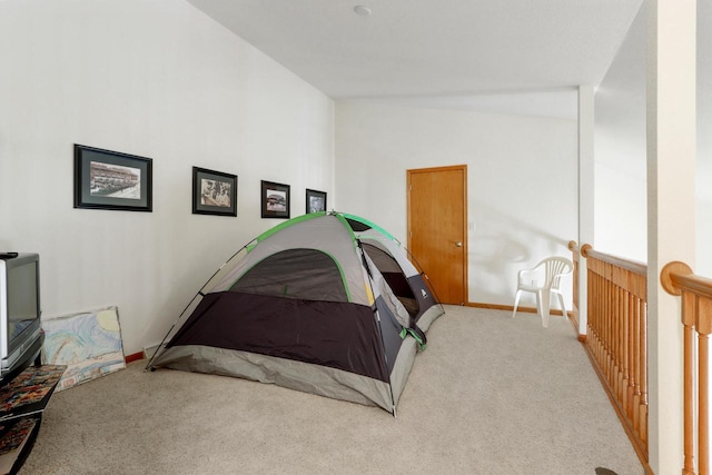 carpeted bedroom with high vaulted ceiling