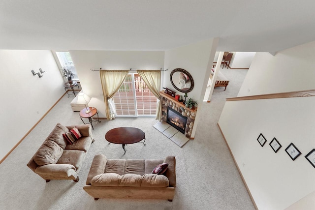 carpeted living room featuring a stone fireplace