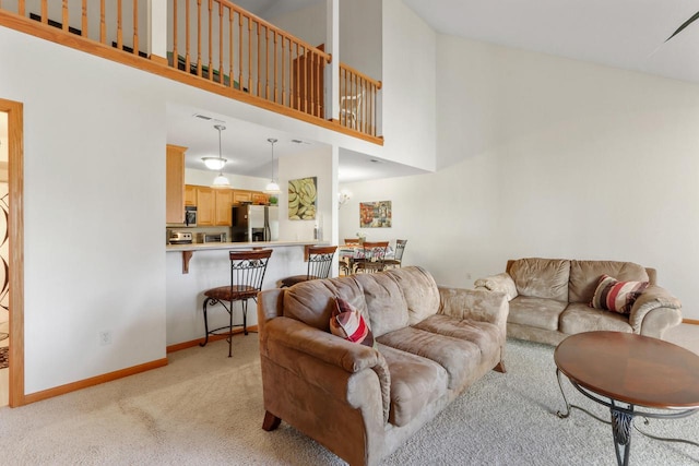 living room featuring light colored carpet and a towering ceiling